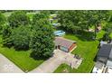 An aerial view shows the home, lawn, above ground pool, large trees, and other outbuildings at 11054 N Shelby 490 W, New Palestine, IN 46163