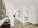 Bright hallway with wood floors, decorative art, and a glimpse into a tastefully decorated bedroom at 11832 Vale St, Indianapolis, IN 46235
