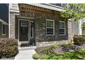 Charming front entry with dark brick, detailed door, and lovely landscaping at 13316 E Lieder Way, Fishers, IN 46037