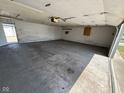 Wide shot of the interior of an empty and spacious garage with a concrete floor and access door at 1546 Kappes St, Indianapolis, IN 46221