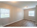 Bright bedroom featuring modern wood flooring, neutral walls, and natural light from two windows at 2109 N Janney Ave, Muncie, IN 47304