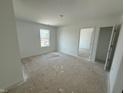 A clean, bright bedroom with ample natural light and a view into the next room at 24517 Wallace St, Sheridan, IN 46069
