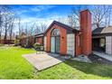 Image displays a brick home's patio and rear exterior, highlighting the backyard and building details at 2979 Amherst St, Indianapolis, IN 46268