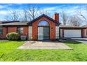 Back exterior view of brick home showcasing patio area with outdoor seating and attached garage at 2979 Amherst St, Indianapolis, IN 46268