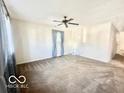 Spacious living room with a ceiling fan, neutral walls, and cozy carpeting at 301 Barton Ave, Indianapolis, IN 46241