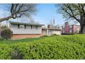 View of a single-story home from the yard showcasing brick accents and lush landscaping at 318 Camby St, Greenwood, IN 46142