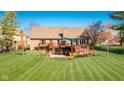 Spacious backyard features a deck with patio furniture, a lush lawn, and mature trees providing shade at 4063 Millstream Rd, Greenwood, IN 46143