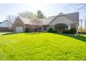 Charming brick home featuring an attached garage, well-maintained lawn and lush greenery in a quiet neighborhood at 4063 Millstream Rd, Greenwood, IN 46143