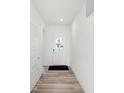 Bright hallway with wood-look flooring and fresh white paint leading to a front door at 4327 Persian St, Greenwood, IN 46143
