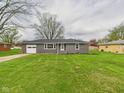 Charming single-story home featuring an attached garage and a well-maintained front yard with mature trees at 4715 Southern Ave, Anderson, IN 46013