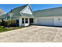 Classic white home with an attached two-car garage, complemented by manicured landscaping at 5129 W Preakness Ct, Muncie, IN 47304