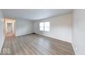 Bright living room featuring new laminate flooring, a front door, and a window allowing natural light at 6501 Meadowlark Dr, Indianapolis, IN 46226