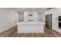 A modern kitchen features a large island, stainless steel appliances, and white cabinets and countertops at 7342 Shroyer Way, Noblesville, IN 46062