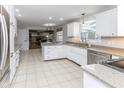 Bright kitchen with white cabinets, granite countertops, stainless steel appliances, and tile flooring at 7811 Hoover Rd, Indianapolis, IN 46260