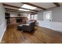Inviting living room featuring hardwood floors, a brick fireplace, skylights, and neutral decor at 7811 Hoover Rd, Indianapolis, IN 46260