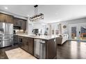 Open kitchen with island, stainless appliances, dark wood cabinets, and modern lighting at 807 E Minnesota St, Indianapolis, IN 46203
