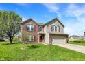 Beautiful two-story home featuring brick accents, vinyl siding, a two-car garage, and a lush green lawn at 8531 Aberdeenshire Ct, Indianapolis, IN 46259