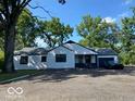 Charming one-story home featuring neutral siding, black trim, an attached garage, and a large front yard at 8560 E 38Th St, Indianapolis, IN 46226
