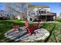 Backyard featuring a stone fire pit area surrounded by Adirondack chairs on a well-maintained lawn at 9789 Logan Ln, Fishers, IN 46037
