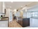 Updated kitchen features an island with a sink, stainless steel appliances, and a view into the living area at 9844 Plantana Blvd, Fishers, IN 46038