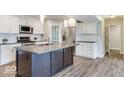 Modern kitchen features white cabinets, stainless steel appliances, a large island, and subway tile backsplash at 9844 Plantana Blvd, Fishers, IN 46038