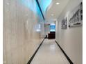 A bright hallway is featured with a marble accent wall, and modern lighting, leading to a reception area at 1 Virginia Ave # 707, Indianapolis, IN 46204