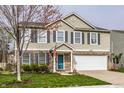 Charming two-story home boasts a well-maintained lawn and an attached two-car garage at 10220 Tournon Dr, Fishers, IN 46037