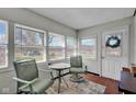 Bright sun room with tiled floor, metal chairs, table, and multiple windows at 11015 S State Road 58, Columbus, IN 47201