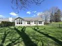 Spacious backyard with lush green grass and mature trees, enclosed with a black metal fence at 11602 Fairgreen Dr, Carmel, IN 46032