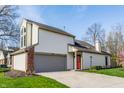 Beautiful two-story house with an attached garage, a red front door and mature landscaping at 11674 Buttonwood Dr, Carmel, IN 46033