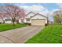 Inviting single-story home boasts a well-maintained lawn and a two car garage at 118 Presidential Ct, Greenfield, IN 46140