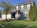 Two-story home with lush green lawn, a beautiful tree, and a two-car garage at 12458 Trumbull Ct, Fishers, IN 46038