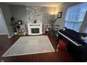 Cozy living room featuring a fireplace, large area rug, and a piano at 12458 Trumbull Ct, Fishers, IN 46038