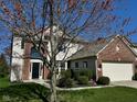 Beautiful home featuring a brick facade, a two-car garage, and a tree in the front lawn at 12802 Ari Ln, Fishers, IN 46037