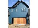 Garage view of a house with blue siding and black trim, plywood over door, under construction at 16387 Burlwood Dr, Westfield, IN 46074