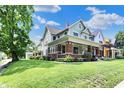 Lovely home featuring mature trees, a spacious lawn, and a welcoming front porch at 1826 N Alabama St, Indianapolis, IN 46202