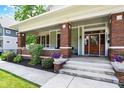 Inviting covered front porch featuring brick columns and a beautifully landscaped entrance at 1826 N Alabama St, Indianapolis, IN 46202