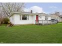 A cozy one-story home with white siding, complemented by a lush green lawn at 217 S 17Th Ave, Beech Grove, IN 46107
