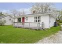 A single-story home features a red front door, white siding, and a wooden deck at 217 S 17Th Ave, Beech Grove, IN 46107