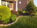 Professionally landscaped front yard with lush green grass, plants, and decorative stone borders at 2325 Silver Rose Dr, Avon, IN 46123