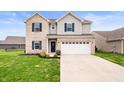 Charming two-story home with brick accents, gray siding, and a spacious two-car garage at 2681 Pumpkin Patch Ln, Indianapolis, IN 46229