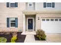 Inviting entryway with a dark blue front door, brick accents, and manicured landscaping at 2681 Pumpkin Patch Ln, Indianapolis, IN 46229