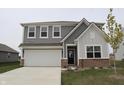 Well-maintained two-story home with gray siding, a two-car garage, and a neatly landscaped yard at 2704 Grassy Br Dr, Whitestown, IN 46075
