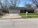 Inviting one-story home featuring a two-car garage, well-maintained lawn, and classic suburban appeal at 3102 Pawnee Dr, Indianapolis, IN 46235