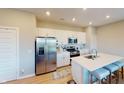 Modern kitchen features stainless steel appliances, white cabinetry, quartz countertops, and a breakfast bar at 3117 Allesley Way, Westfield, IN 46074