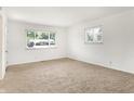 Bright, empty room with two windows and neutral carpet flooring at 3809 Wildwood Dr, Indianapolis, IN 46239