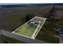 Aerial view of a single Gathering home on a large lot, outlined in white with a gravel driveway leading to the street at 4653 E Us Highway 36, Markleville, IN 46056