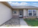 Home entrance featuring neutral siding, brick accents, and a walkway leading to the front door at 5213 Milhouse Rd, Indianapolis, IN 46221