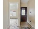 Home entryway featuring a door with decorative glass and an open doorway to a room with a large window at 5213 Milhouse Rd, Indianapolis, IN 46221