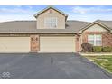 Attached two-car garage showcasing a brick facade, offering convenience and ample parking space for residents and guests at 5324 Rolling Meadow Blvd, Indianapolis, IN 46237